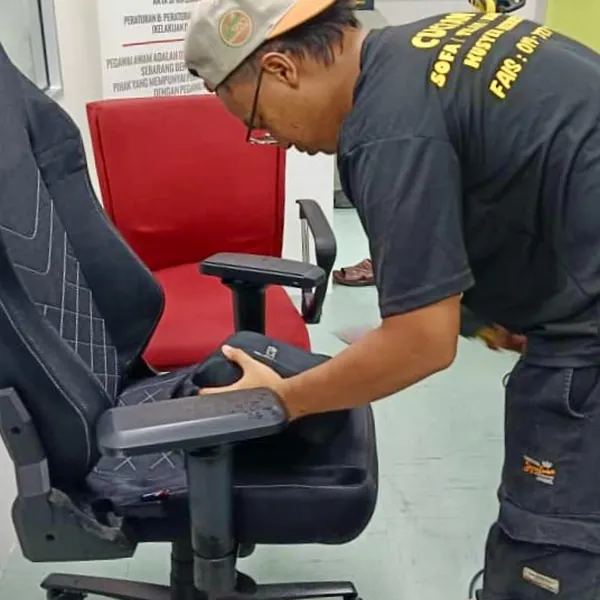 Kerusi pejabat merah dibersihkan dengan alat ekstraksi