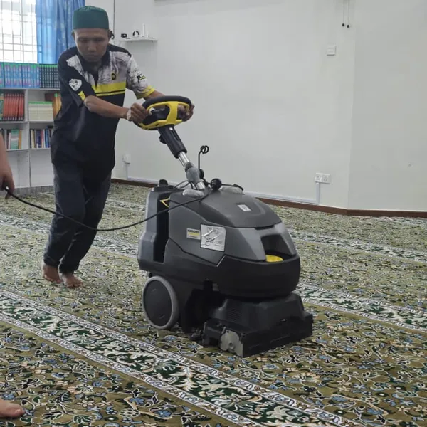 Pekerja membersihkan karpet surau dengan mesin ekstraksi