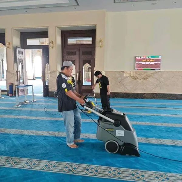 Pekerja mencuci karpet biru masjid mengikut baris saf