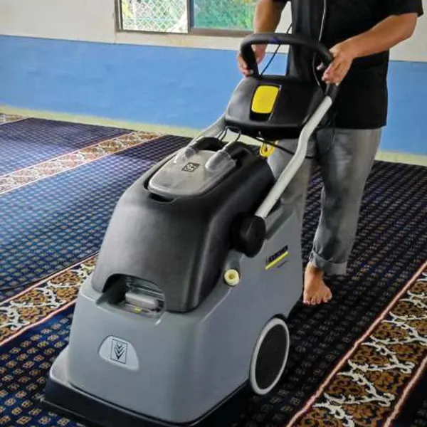 Pekerja mengendalikan mesin cucian karpet di ruang solat masjid